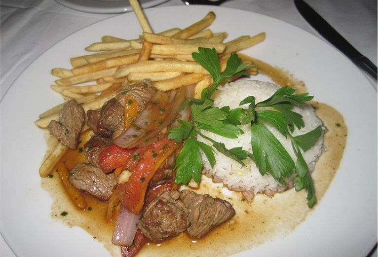 Think stir-fried beef strips with tomatoes, onions, and aji peppers